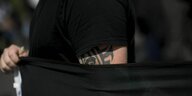 Auf dem Oberarm eines Teilnehmers am Hess Gedenkmarsch ist ein Tattoo, das einen Soldaten mit Stahlhelm und Runen zeigt