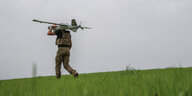 Ein Soldat trägt eine Drohne auf dem Rücken